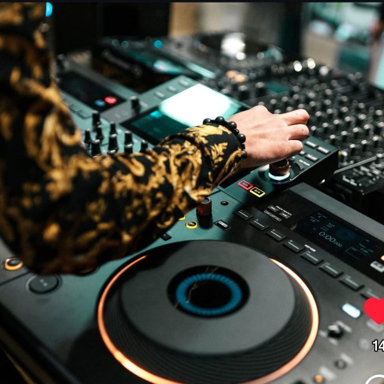 Main d’un DJ réglant une table de mixage entre deux platines